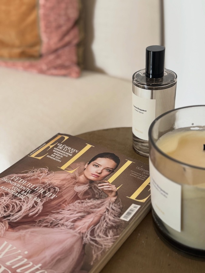 Instagram-Beitrag: ELLE-Magazin, Duftkerze und Parfumflakon auf einem Beistelltisch